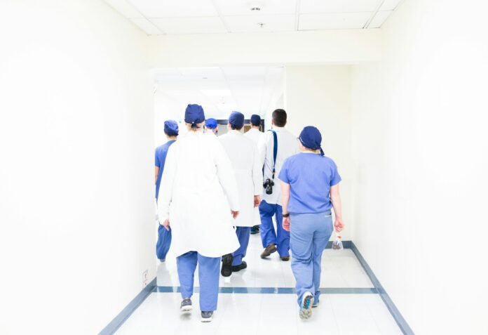 Photo by Luis Melendez group of doctors walking on hospital hallway