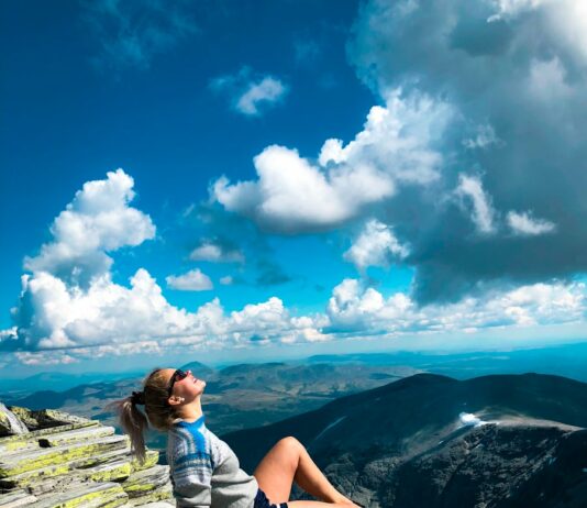 운동으로 삶을 변화시키는 법: 신체와 정신의 조화 woman sitting on peak of mountain