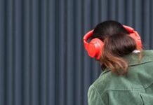 음악 감상으로 겨울 스트레스 날리기 a woman wearing red headphones and a green jacket
