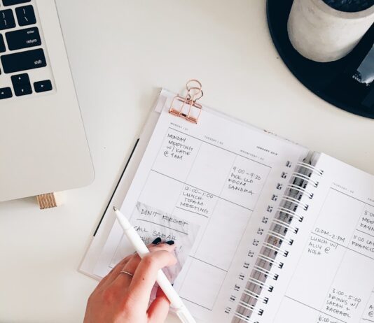 자기계발을 위한 일일 계획 작성법 person holding notepad and pen flat lay photography