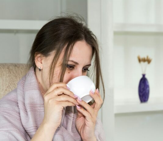 “피곤하면 항상 감기부터 걸린다”…면역력 낮은 사람의 공통점 a woman sitting in a chair drinking from a cup