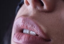 “입술이 자꾸 따갑고 붉어져요”… 립밤을 자주 바를수록 입술염이 심해진다? person with red lipstick and black mascara