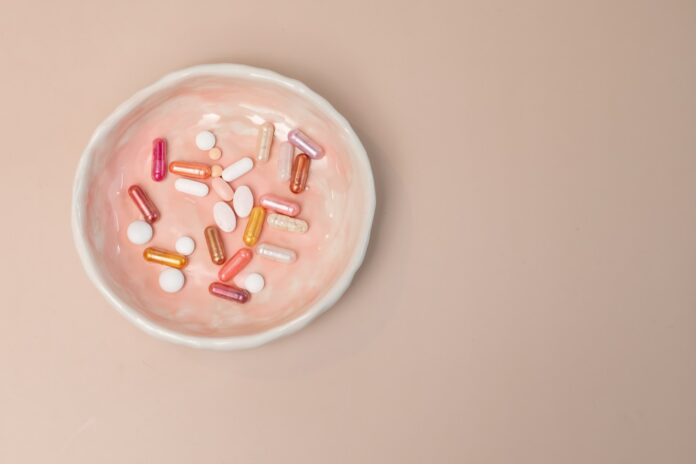 Photo by laura adai A white bowl filled with pills on top of a table